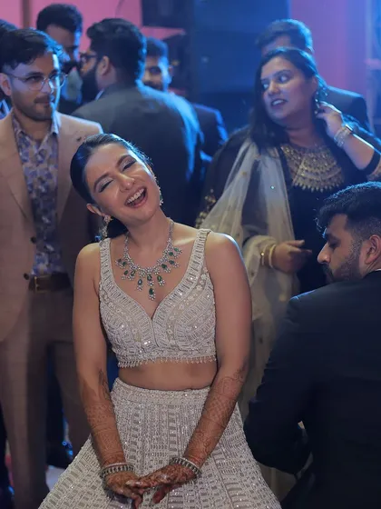 A bride's infectious laughter on the dance floor during her Sangeet. This photo is pure, unadulterated joy.