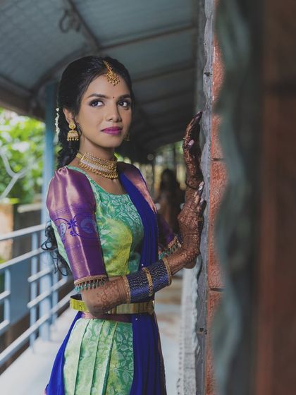 This engagement look is vibrant and youthful. The bride's colorful half-saree is paired with a bold lip and bright, defined eyes.