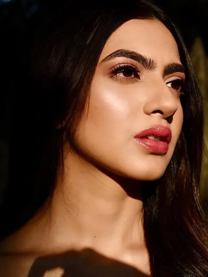 A close-up profile view, where the sunlight catches the highlighter on her cheekbones and the shimmer on her eyelids. This demonstrates my technique for creating a multi-dimensional glow.