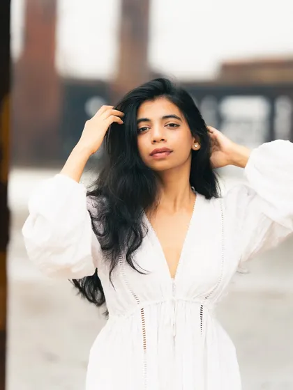 A close-up shot focusing on the model's beauty and the texture of her hair, with the soft, blurry background keeping the attention on her.
