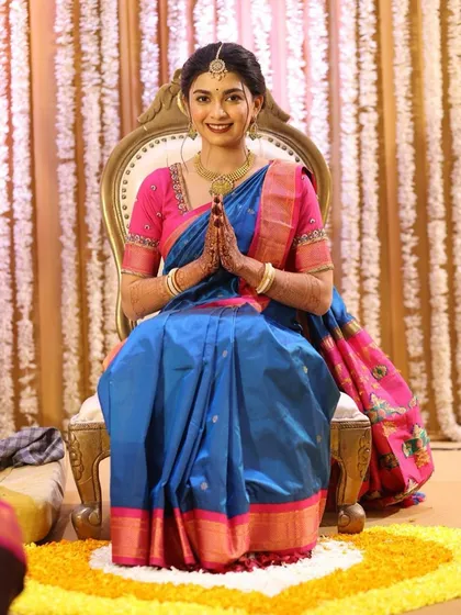 A natural, skin-like makeup look for an engagement ceremony. The bride looks serene and beautiful in her blue and pink silk saree.