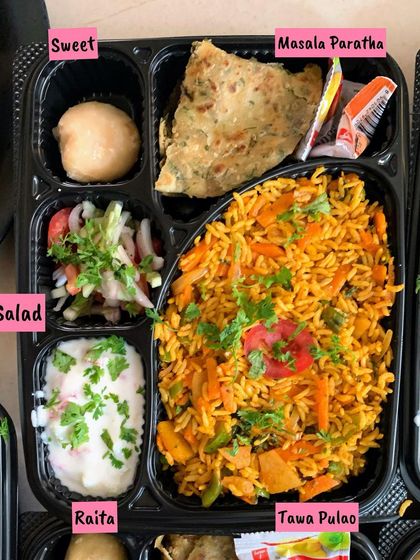 A simple yet satisfying meal for the road. This tray features my flavorful Tawa Pulao, a soft Masala Paratha, fresh salad, cooling raita, and a homemade sweet to complete the meal.