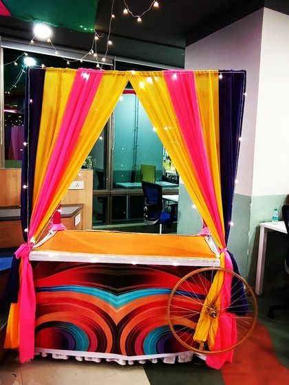 Colorful stalls set up for a wedding event. These can be used for food, games, or as fun photo opportunities for guests.