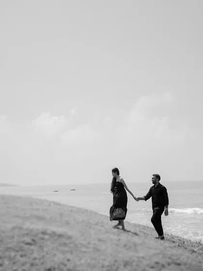 A minimalist black and white shot of the couple walking on a hill overlooking the sea. This image feels vast and epic, symbolizing their journey together.