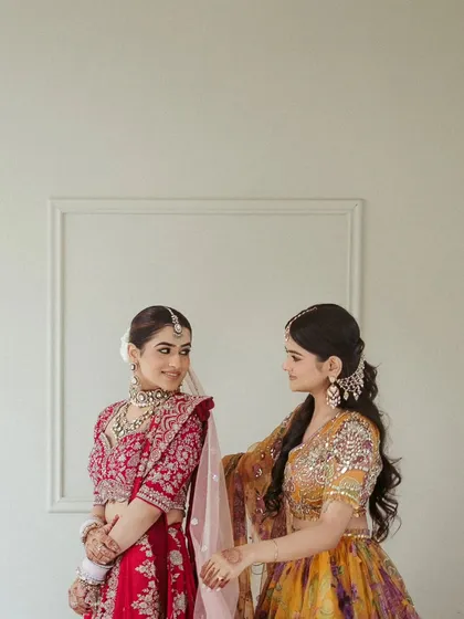A sweet, candid moment between the bride and her sister. These interactions are a precious part of the wedding day story.