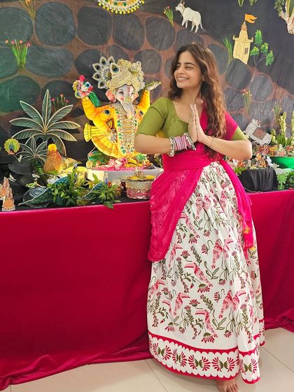 A beautiful moment during Ganesh Chaturthi in a flowy lehenga skirt and a fitted green blouse. The A-line shape of the skirt is perfect for pear shapes, offering comfort without sacrificing style.