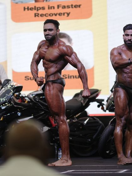 Side tricep pose in front of the BMW I won. Showcasing the conditioning and muscle separation from every angle.