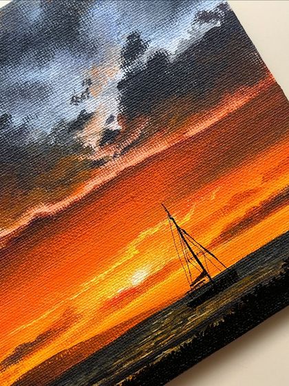 A close up shot of the sailboat sunset painting, focusing on the vibrant colors of the sky.