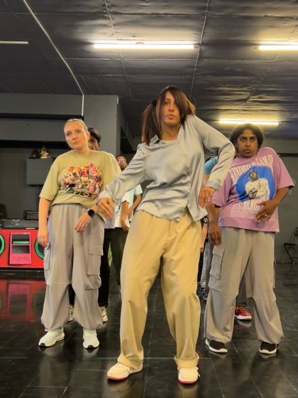 A closer look at a popping drill in progress. Notice the focus and control. We teach our students to understand their bodies and the music, ensuring every movement is intentional and clean.