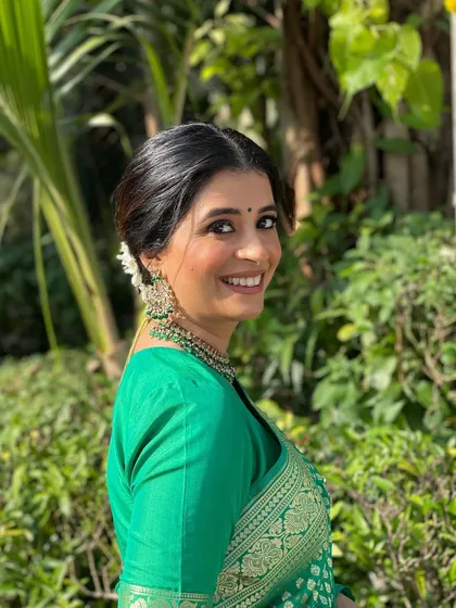 A lovely side profile of the client, showcasing her glowing makeup and the traditional gajra hairstyle.