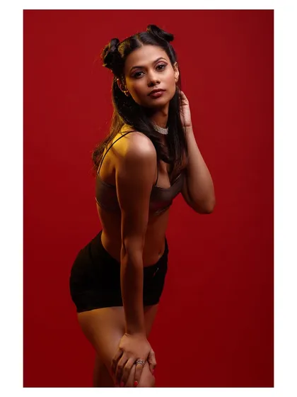 A simple yet powerful pose that showcases the outfit against the striking red backdrop.
