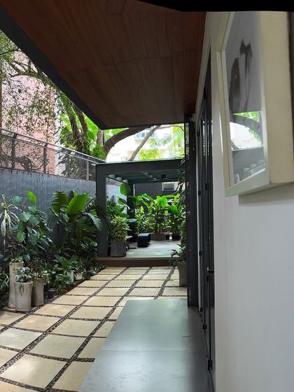 This long corridor-like outdoor space was transformed into a green walkway. The stone path is flanked by a variety of plants in pots and planters, making the journey through the space an experience.