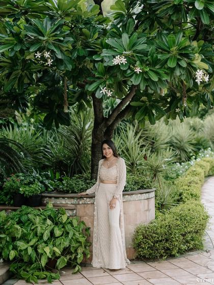 A lovely solo portrait of the bride-to-be in a lush garden setting, looking elegant and happy.
