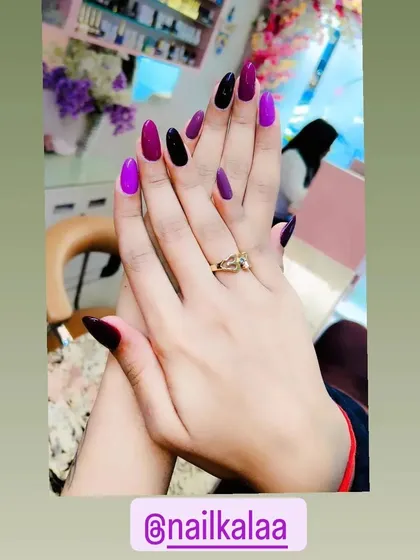 A bold color-blocking design with shades of deep purple, vibrant magenta, and black on almond-shaped nails.