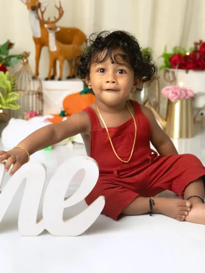 Posing with the "One" sign. This is a classic first birthday shot that every parent loves to have in their collection.