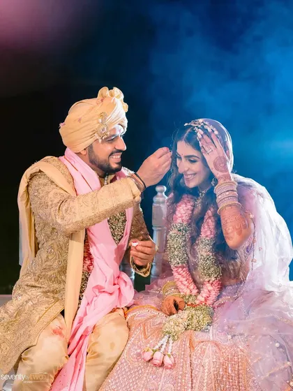 A sweet, candid moment where the groom adjusts something in the bride's hair, a small gesture of love and care.