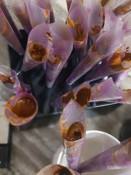 The process of filling my empty cone sheets with fresh henna paste. Each cone is filled carefully to the right amount for easy handling.
