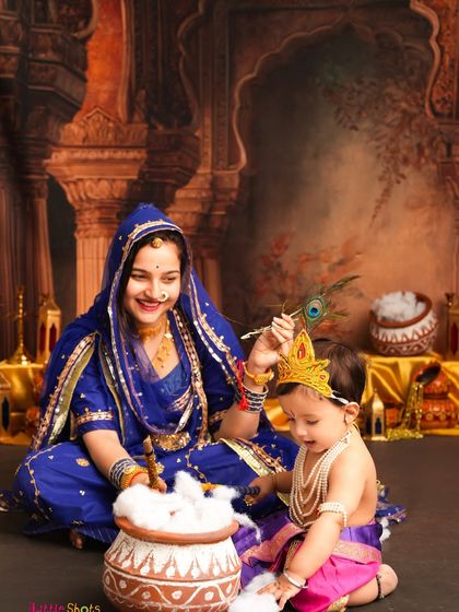 Little Krishna gets curious about the pot of "butter." This interactive and playful shot captures the fun and spirit of the festival.