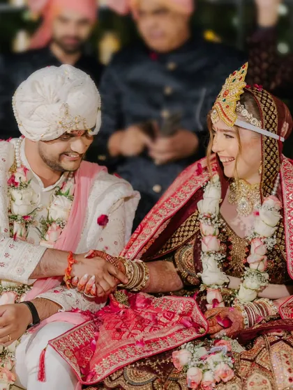 A moment of connection during the wedding ceremony. The couple holds hands, their smiles reflecting the joy and significance of their vows.