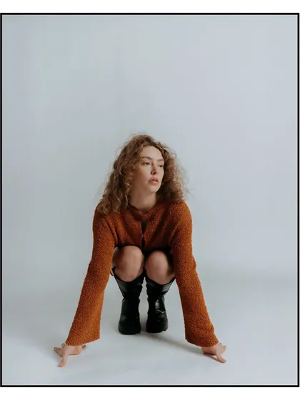 A modern pose for a Flanelle Magazine editorial. The low-angle squat and clean background create a strong, graphic image that feels contemporary and fresh.