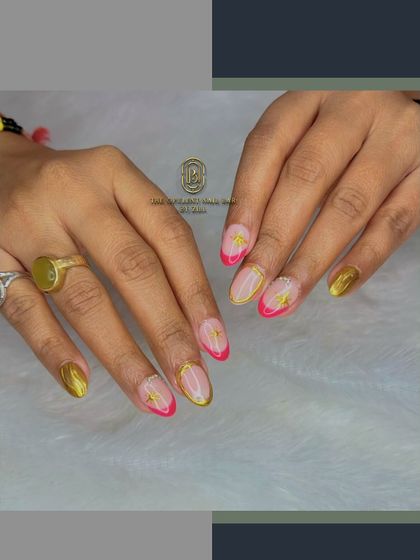 A touch of gold and a pop of pink come together in this luxurious design. The combination of a hot pink French tip with gold chrome accents is both bold and elegant.