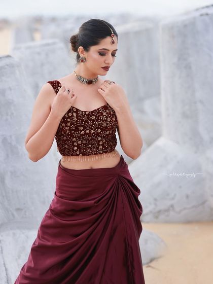 A beachside fashion shoot for a designer's modern-ethnic collection. The models are posed against the sea and coastal rocks to create a windswept, editorial feel that highlights the clothing.