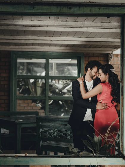 Using architectural elements like this window frame to create a unique and intimate portrait during a pre-wedding shoot.