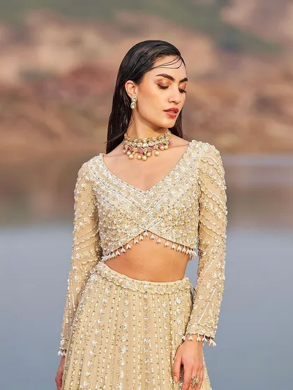 A close-up of the embellished blouse, showcasing the intricate beadwork and flattering neckline.