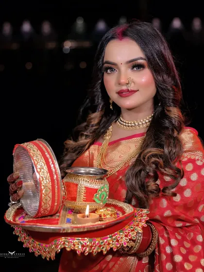 A beautiful portrait of the model holding the festive thali, looking directly at the camera.