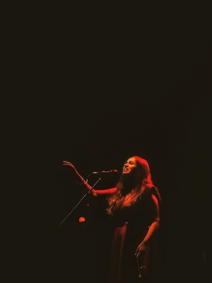 A single red light illuminates the stage during the 'Vari' album release concert. The mood and lighting are so important for setting the emotional tone of the music.