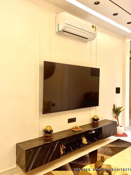 A close-up of the sleek, floating TV console with a black marble finish. This custom furniture piece provides storage while maintaining a clean, minimalist look in the living room.