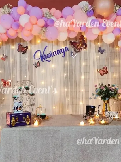 A soft and dreamy butterfly theme with a pastel balloon arch against a fairy-lit curtain. This setup is perfect for a whimsical celebration.