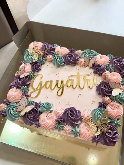 This floral sheet cake is as beautiful as it is practical. The square shape is easy to serve, and it's generously decorated with piped rosettes in shades of purple, pink, and teal.