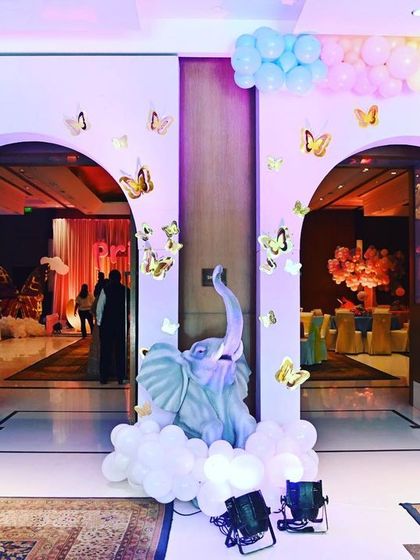 The entrance to this fantasy-themed first birthday featured pastel balloon arches dotted with golden butterflies. A gentle elephant statue sits among clouds of balloons, welcoming guests to a dream-like celebration.