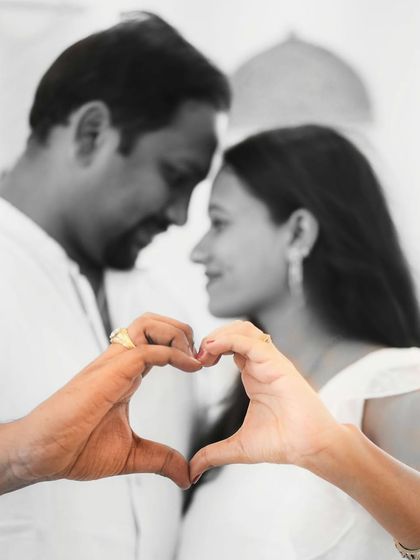 A creative and artistic shot focusing on the couple's hands forming a heart. This black and white photo with a touch of color is a unique way to symbolize their love.