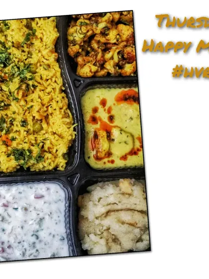 This thali includes a fragrant masala pulav, cooling raita, paneer in a light yellow gravy, dry gobi sabzi, and a comforting suji halwa.