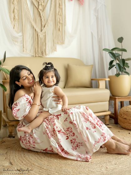 A mother and daughter sitting on the floor of our studio, sharing a happy moment.