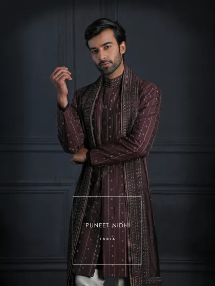 A masterpiece of tradition and refinement. The wine Achkan with pintucked textures and an intricately bordered stole is created for moments that deserve grandeur.