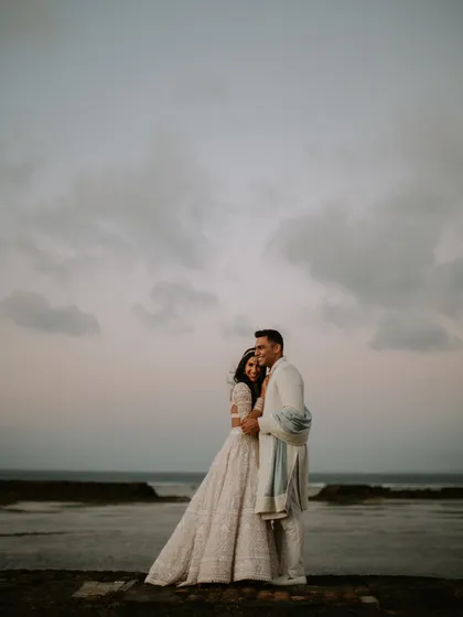 A beautiful shot of the couple against the Bali seascape. The intricate details of her Manish Malhotra lehenga and the subtle elegance of his Anita Dongre sherwani are on full display.