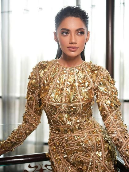 A close-up of the wet-look glam, showing the flawless skin and the way the light catches the highlight on the cheekbones.