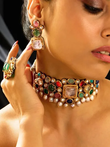 A vibrant navratna-style choker, featuring an array of colorful gemstones set in a traditional design with pearl accents. A perfect piece to add color to any festive look.