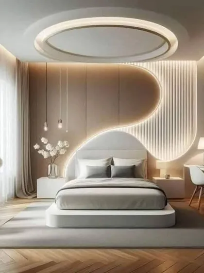 A futuristic and serene bedroom design. The curved, backlit accent wall and the circular false ceiling create a soft, flowing, and ultra-modern aesthetic.