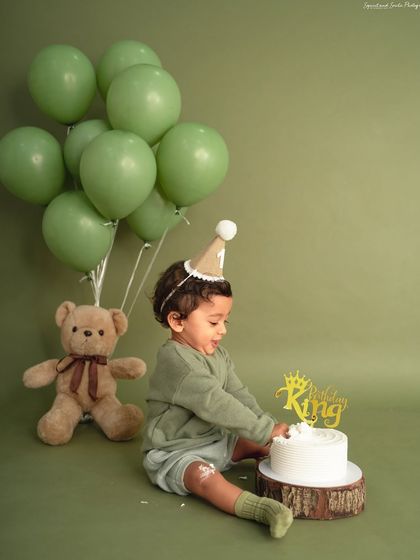 The first touch of the cake is always a special moment. This little birthday king is tentatively exploring his cake in our minimal, olive green themed setup.