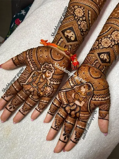 This design features beautiful portraits of a couple in a classic pose. The surrounding patterns are filled with fine details, and you can even see the small elephant motifs on the arms.