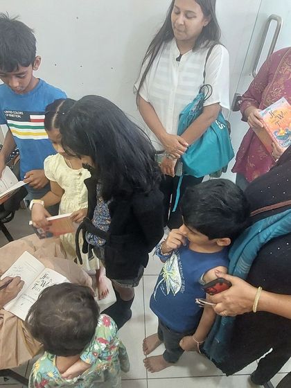 After the story is told, the connection remains. Here I am, signing books for children and their parents at Kahani Box. Each signature is a small continuation of the story we just shared.