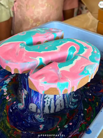 The magic of fluid art in action. This close-up shows the incredible moment when colors meet and marbleize on a wooden letter. It's a mesmerizing process that is just as fun as the beautiful result.