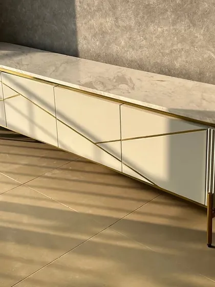 A custom TV unit inspired by our Inlay Console design. This piece features a marble top and a unique geometric pattern on the doors, with a mix of fluted and smooth textures.