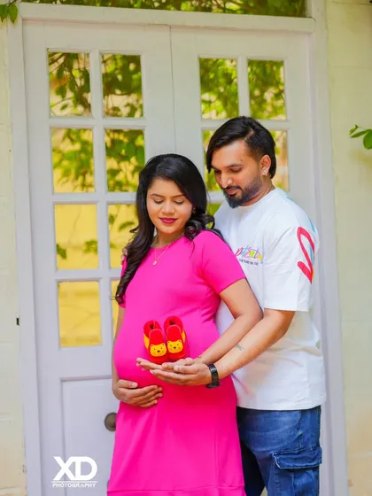 A sweet moment with a couple holding tiny baby shoes, symbolizing their journey to parenthood.