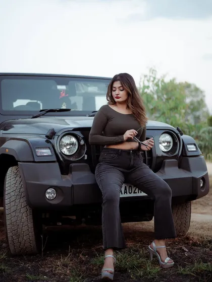 A duplicate of image 476, this portrait of a model sitting on the hood of a Thar jeep combines fashion with a sense of adventure.
