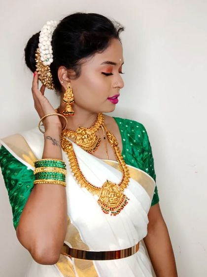 This is a festive Onam look I created on myself. It features a classic Kerala saree with a green blouse and traditional gold temple jewelry.
